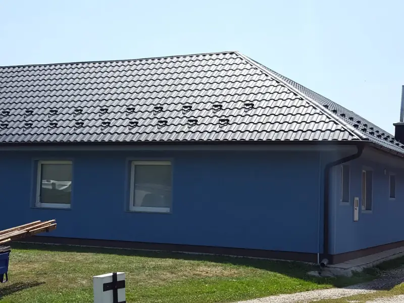 Antracitna kovinska kritina s snegobrani na pritlični hiši s štirikapno streho