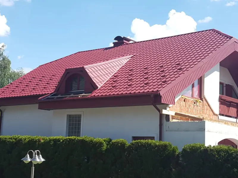 Rdeča kovinska kritina s frčado in obrobami na stanovanjski hiši